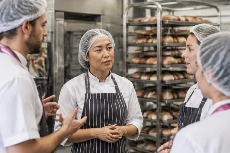 An experienced bakery colleague answering questions from the production team